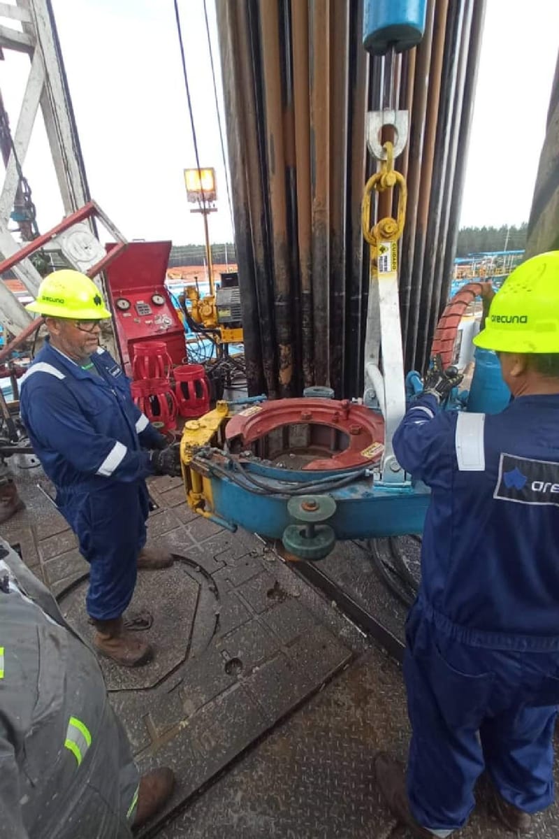 Personal de Arecuna operando una llave hidráulica en el taladro